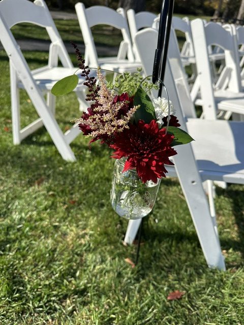 Burgundy mum and pink astilbe on ceremony shepherd's hooks