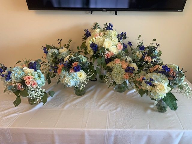 Light blue hydrangea, pink rose, and blue delphinium bridesmaid bouquets