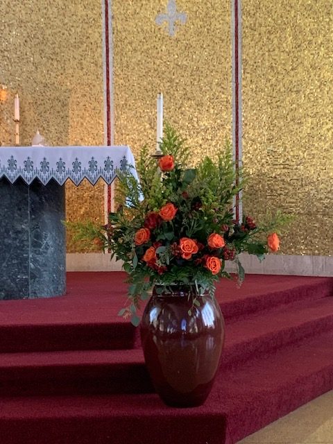 Orange and red rose church ceremony arrangement