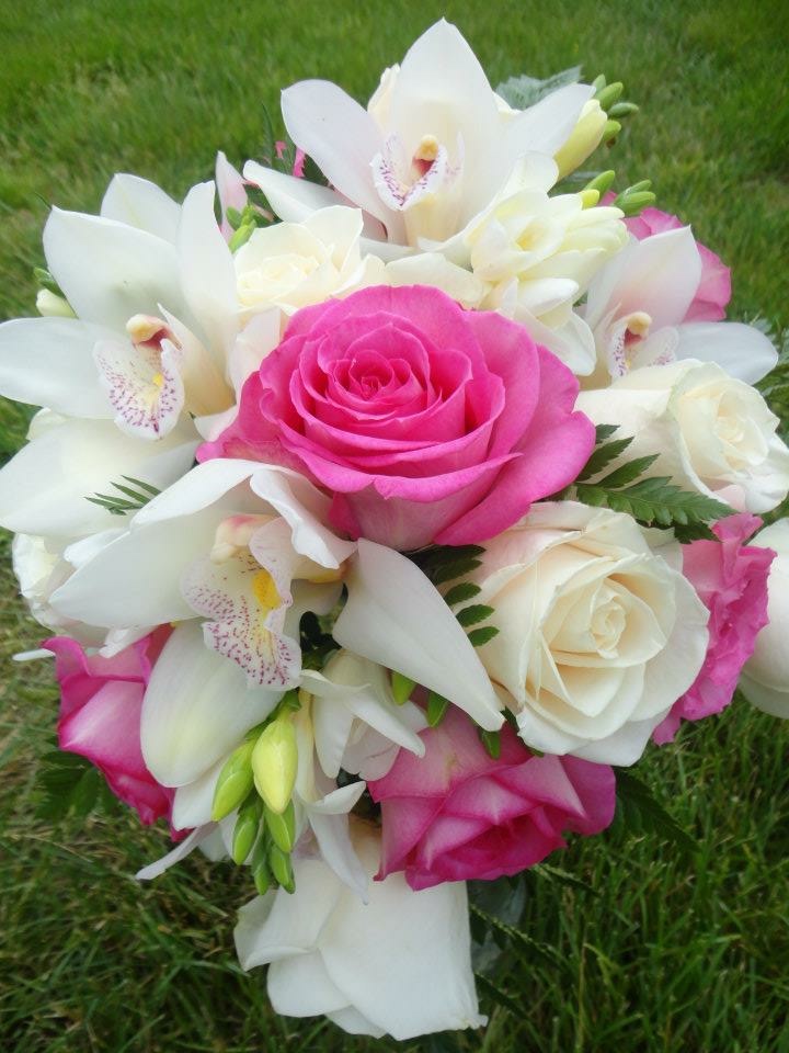A bridal bouquet of orchids and pink roses designed by Plenty of Petals