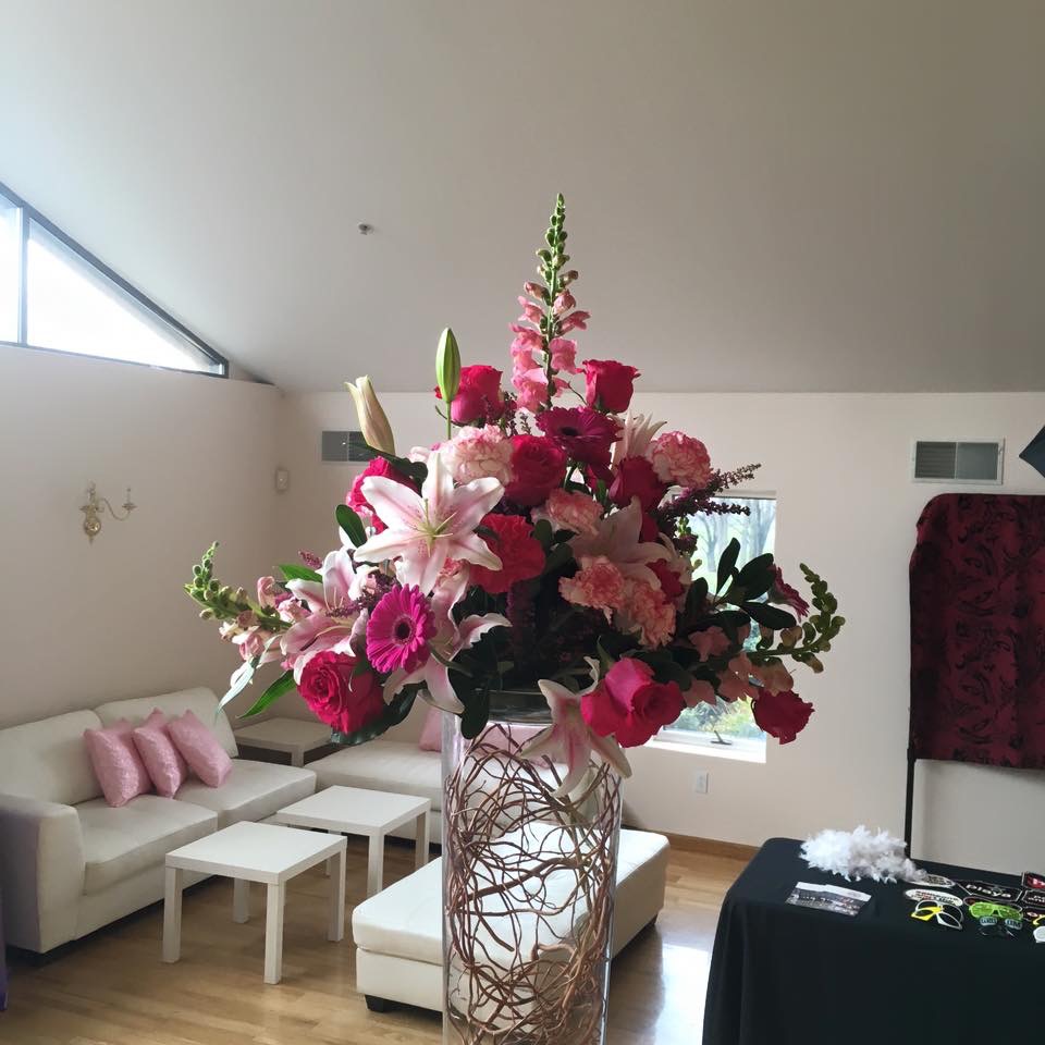 Centerpiece of pink roses, snapdragons, and lilies