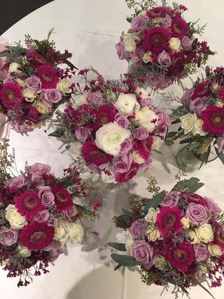 Bridesmaid bouquets of purple roses, scabiosa, and white roses
