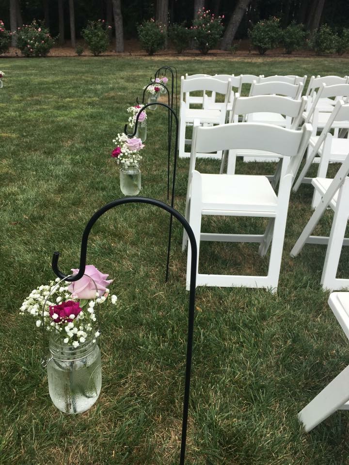 Rose and baby's breath shepherd hooks lining a ceremony aisle
