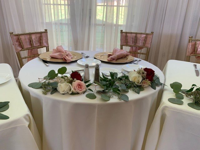 Sweetheart table with a greenery and rose garland