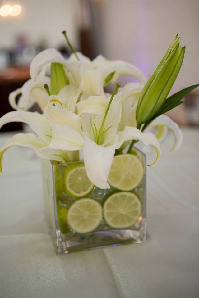 An event centerpiece arrangement of white lilies with lime accents by Plenty of Petals