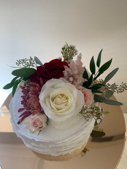 Fresh flower cake topper of white rose, sweetheart rose, and burgundy mum